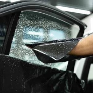 Instructor demonstrating tint application in widows tinting classes