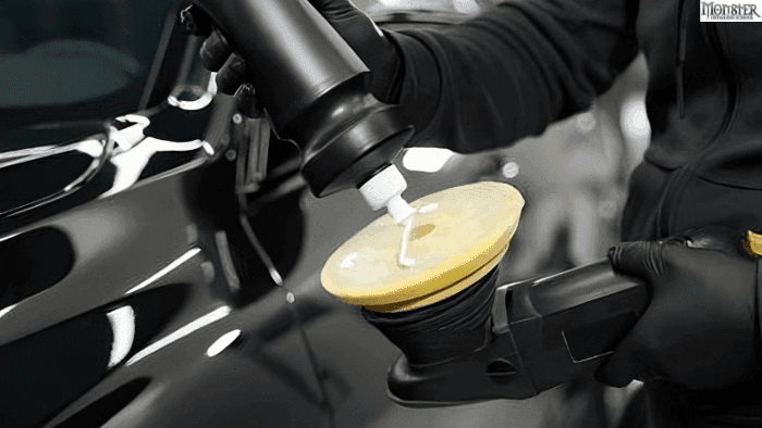A person putting car wax on car polishing machine.