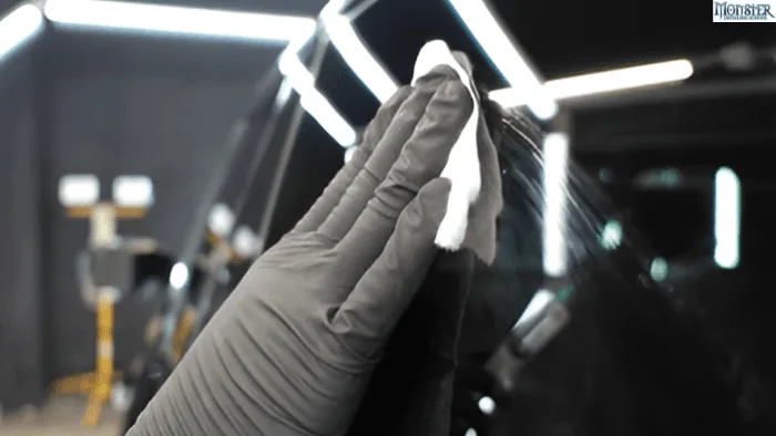 A person applying protective compound on a car.