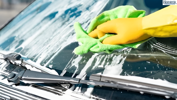 A person gently washing car with microfiber cloth and mild soap.