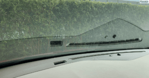 Inside of a car windshield with dashboard reflection.