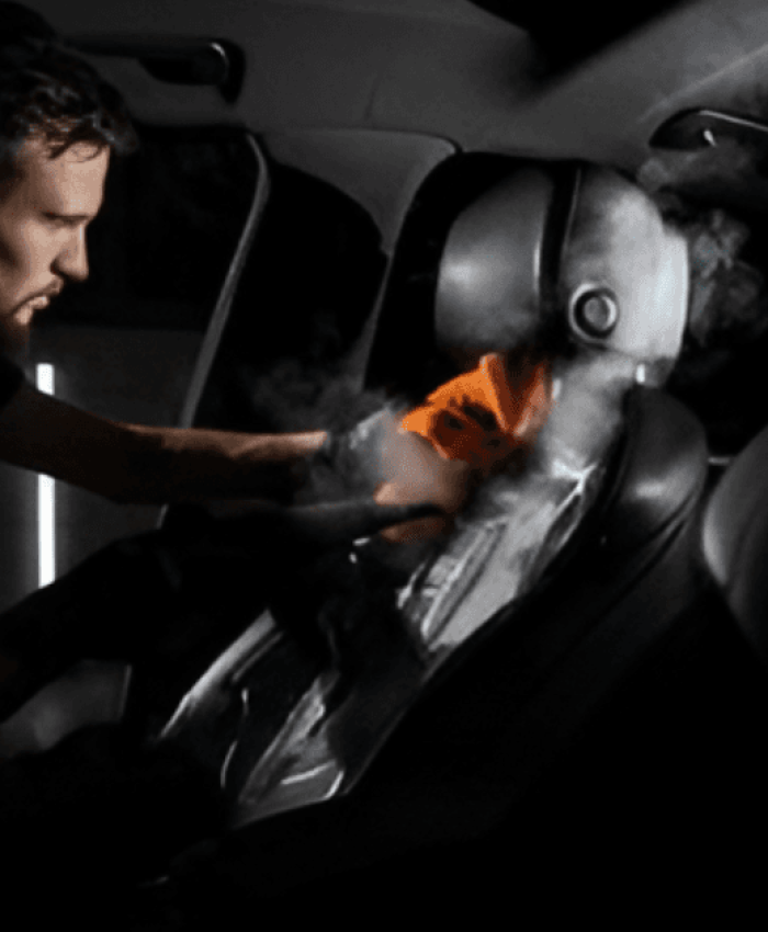 A man steam cleaning leather car seat.