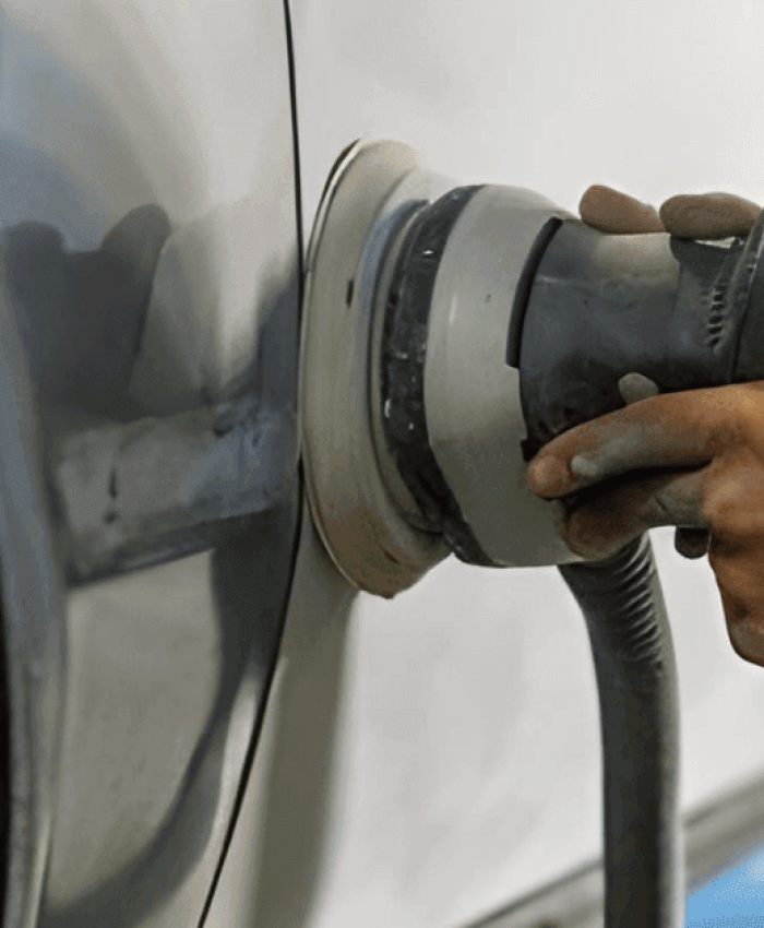 A person sanding a car with dual action polisher.